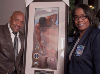Sparkle Adams (right) City Councilwoman from Forest Park, Ga is joined by artist Gilbert Young who created a special edition of his famous painting "He Ain't Heavy" honoring America's Veterans. He also founded Elevating Veterans Through Art.